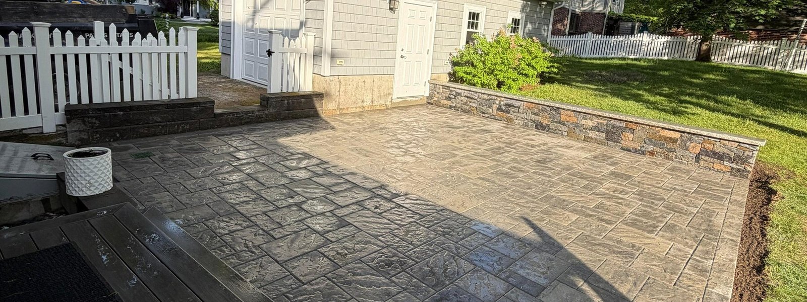 Bluestone patio meeting a stained wood deck behind a home