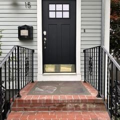 Brick steps and rails at a black front door
