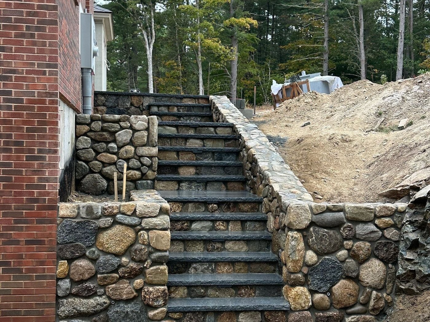 Fieldstone retaining wall with bluestone treads set into a hillside