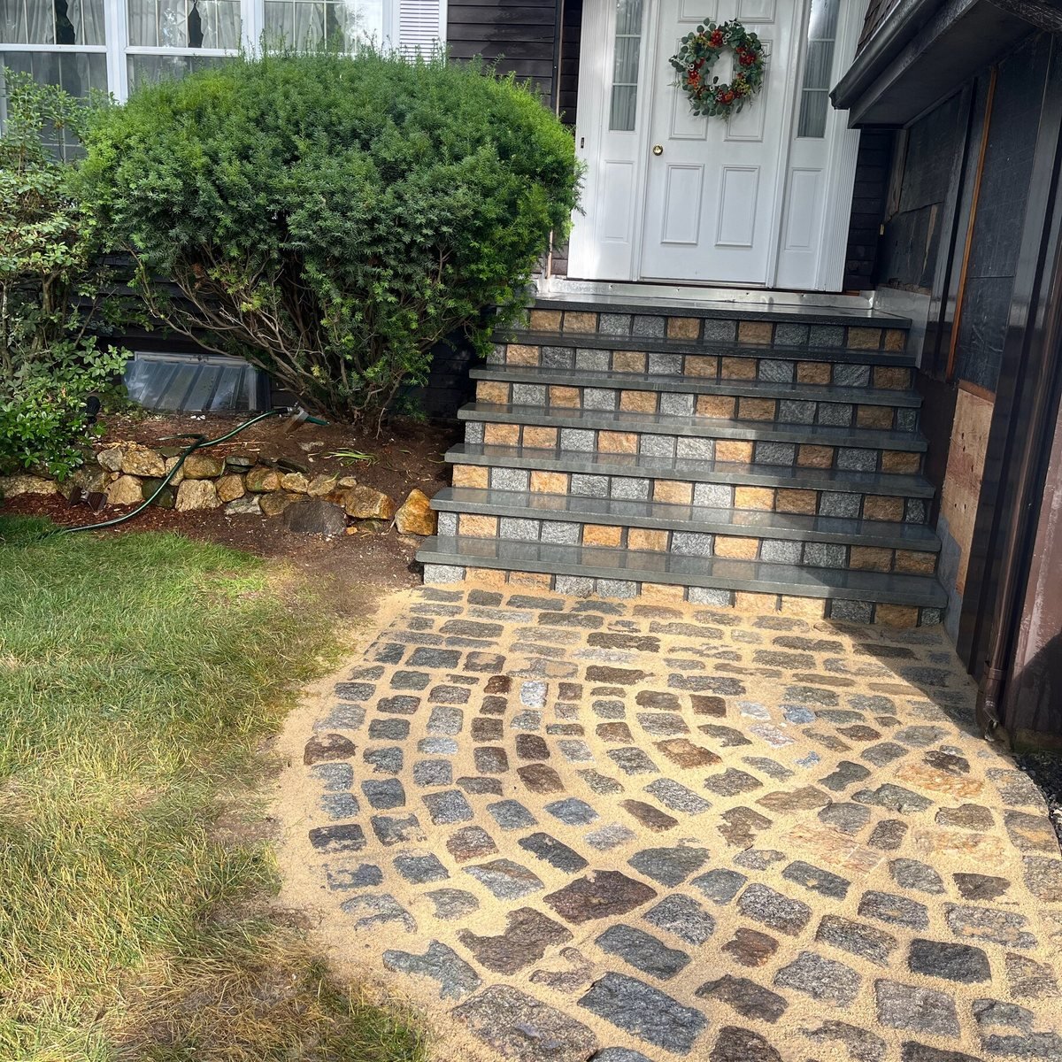 Cobblestone circle walkway leading to bluestone and granite steps